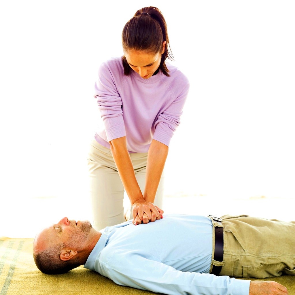 Mulher fazendo massagem cardíaca em homem com parada cardíaca.
